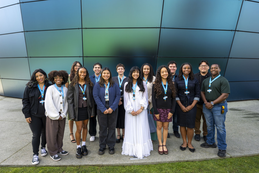 group of fifteen CELP scholars stand in front of the Pacific Visions glass wall outside of the Aquarium