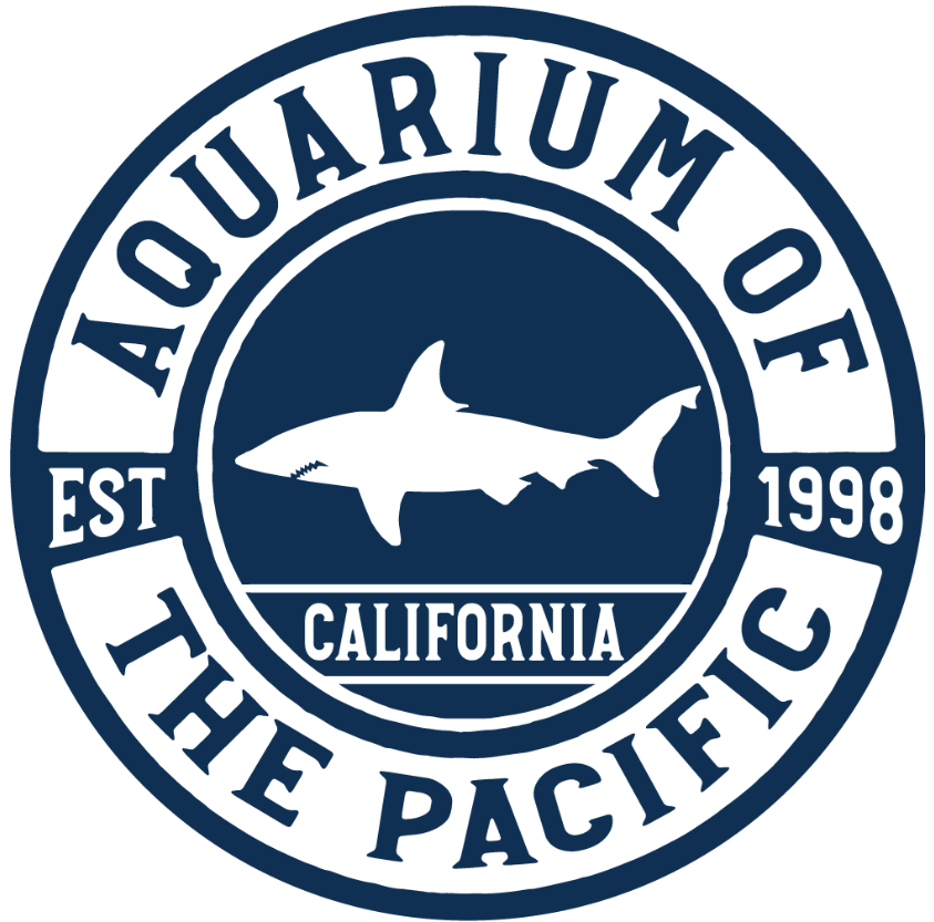 A logo-type graphic featuring the text Aquarium of the Pacific, a silhouette of a shark centered within a circular design with the establishment date of 1998.