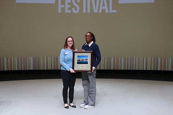 two people standing holding an award