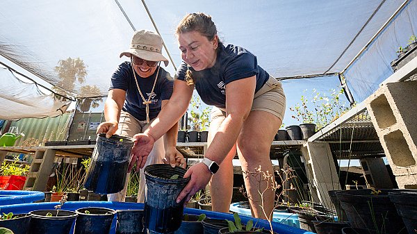 Two Aquarium staff holding pots