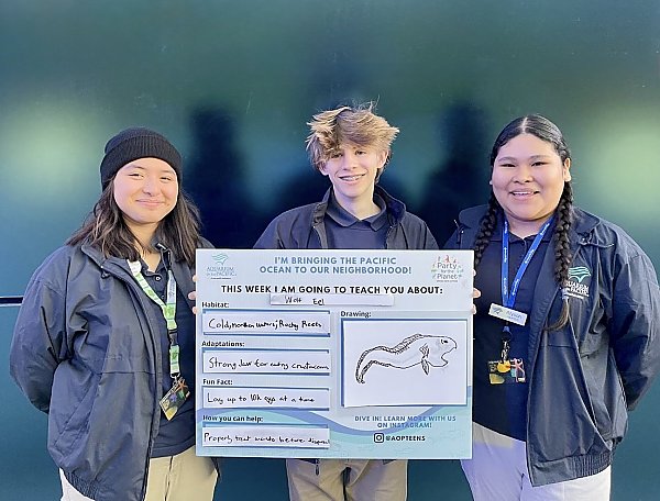 Youth stewards holding a home-made Ocean Neighbors sign about wolf eels