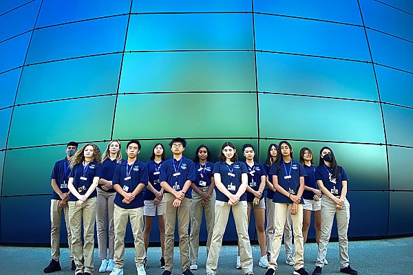 Group of teen volunteers pose in front of the Pacific Visions building