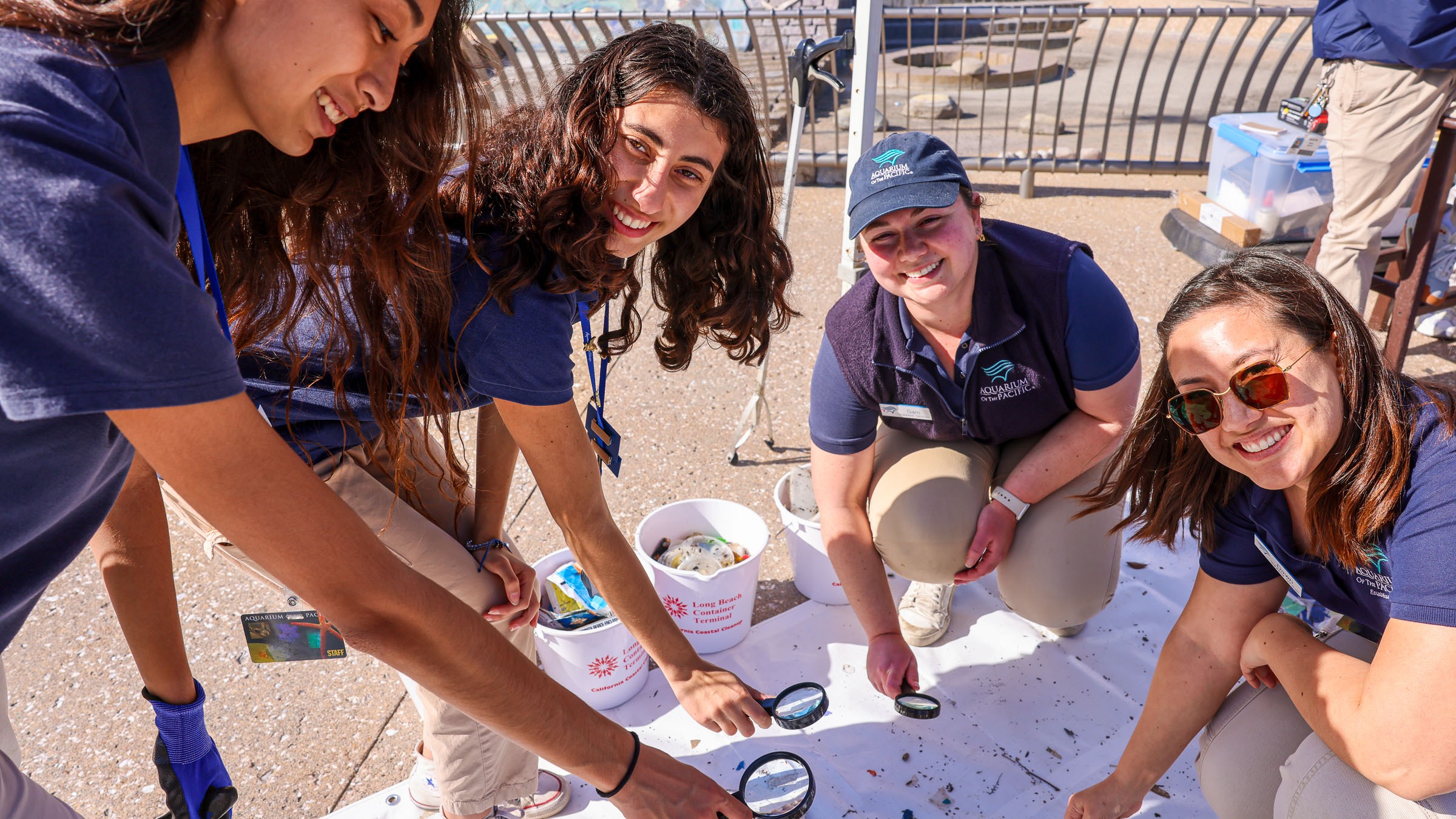 Group of people posing with grass filled wheelbarrow