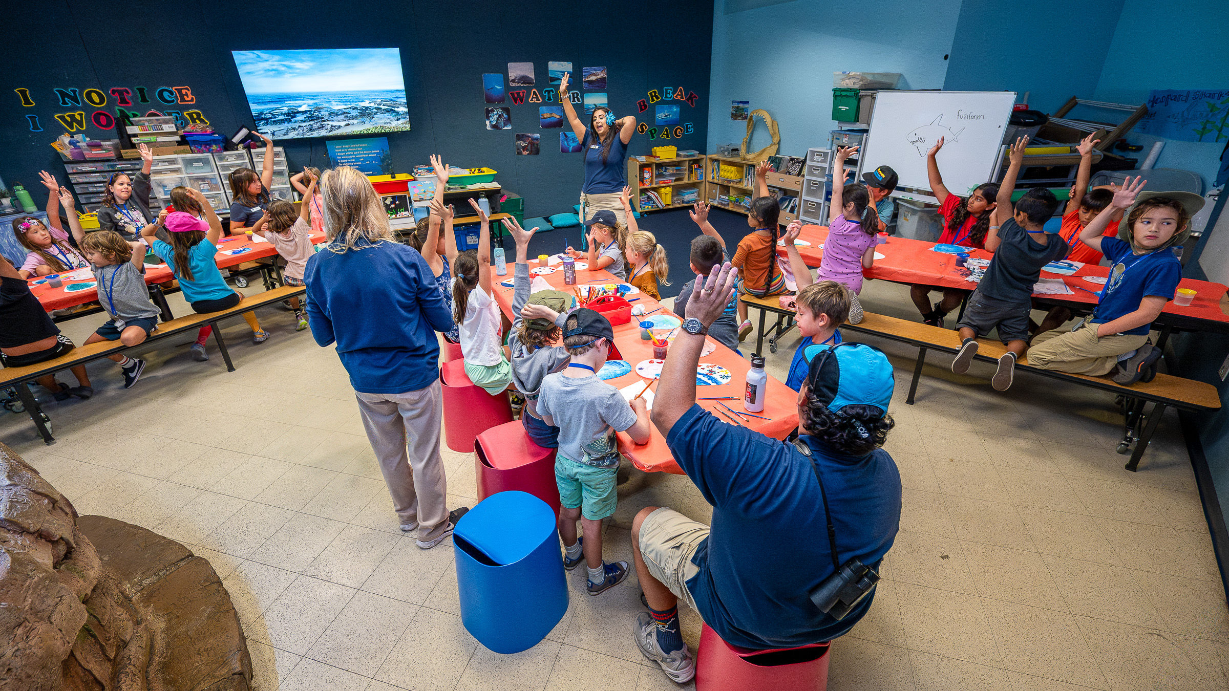Classroom with kids raising hands