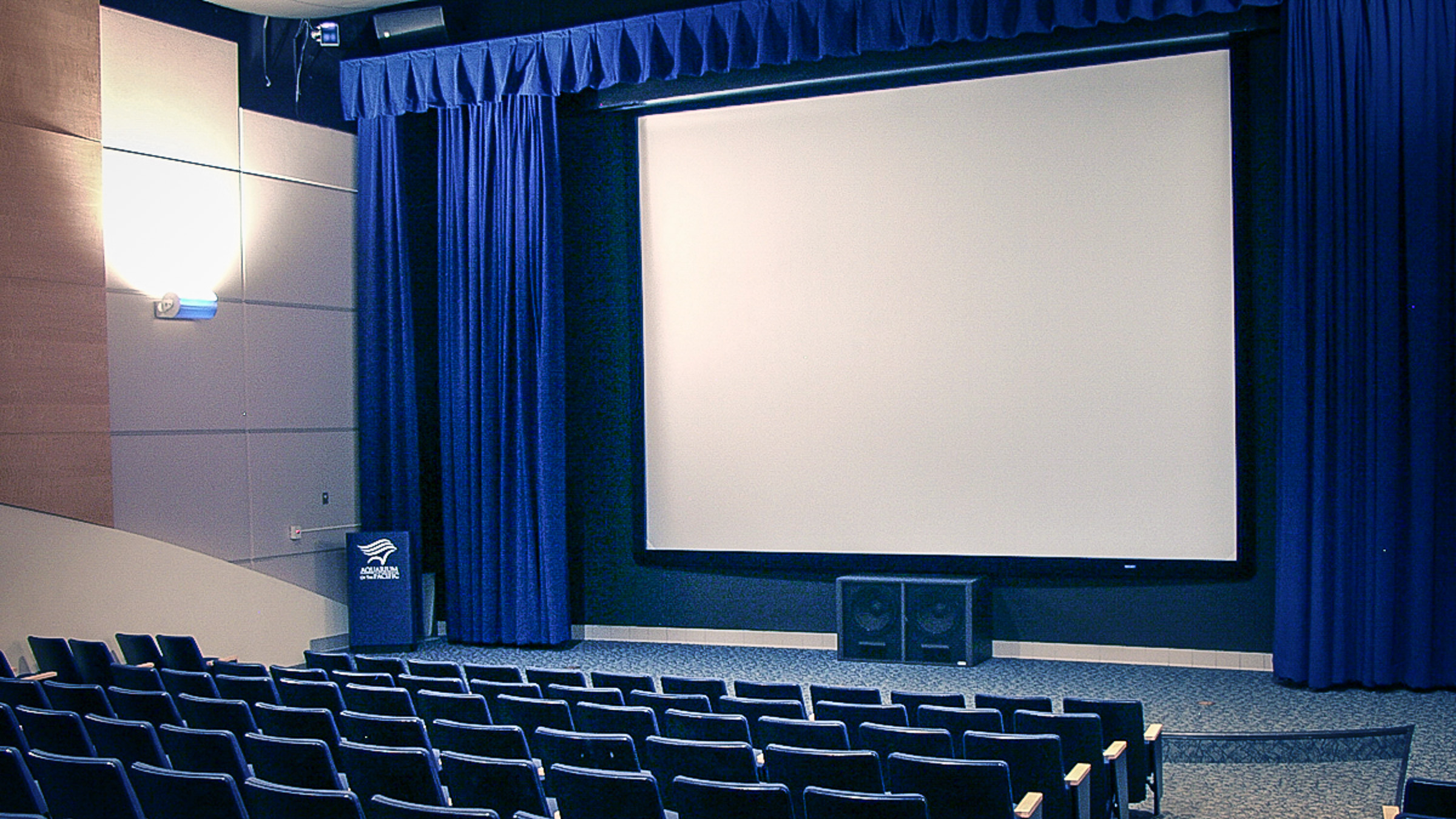 Theater with empty chairs facing screen
